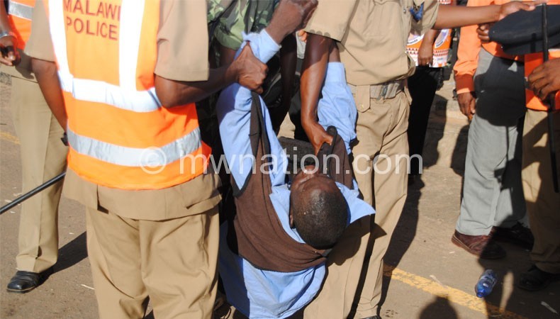 Police officers assist an injured person at Goliati during the rally