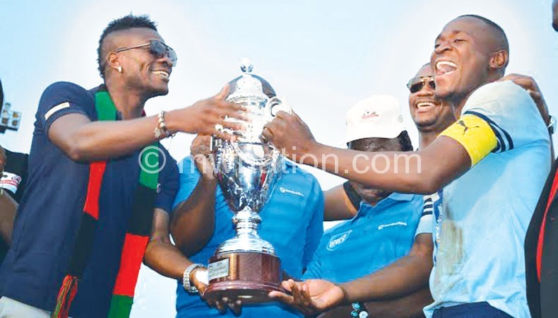 Ghana soccer star Asamoah Gyan (L) presents trophy 
to Silver Strikers captain Lucky Malata