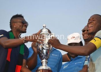 Silver captain Lucky Malata (R) receives a trophy from Asamoah Gyan