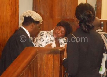 Treza Senzani (In White) consulting with her lawyer, Mhura