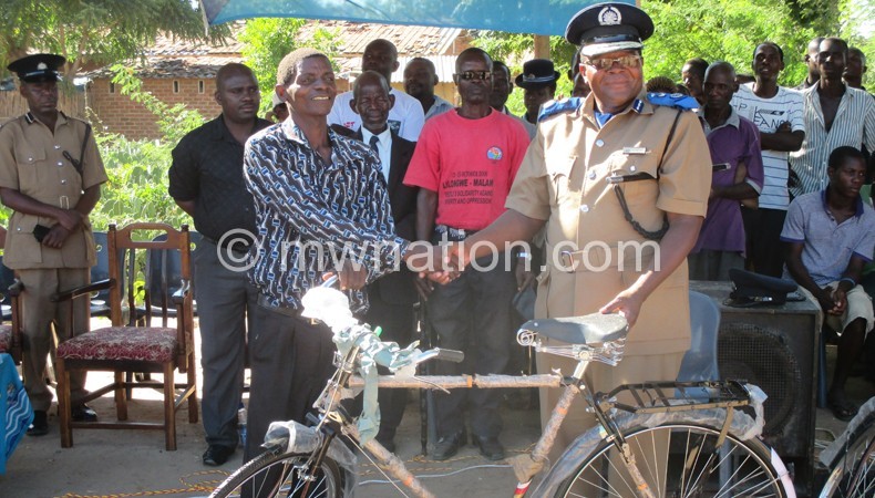 Kainja (R) handing over a bicycle to Mbenje