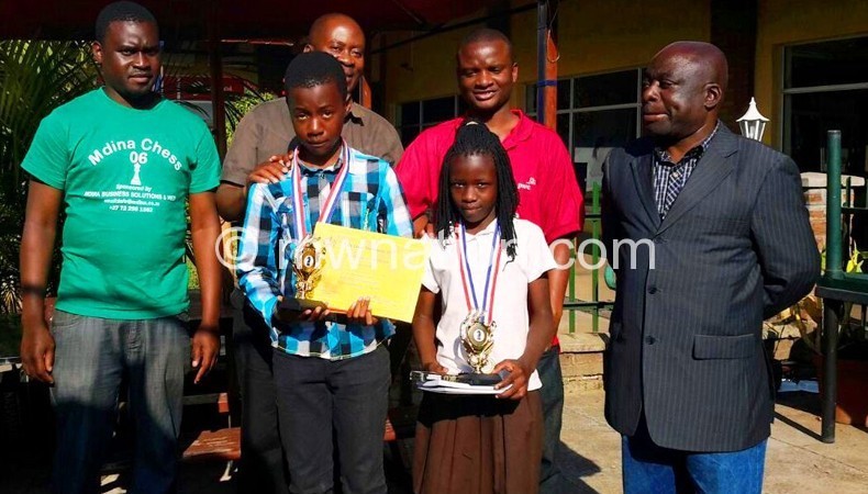 Chess champions Linje (2ndL) and Gondwe (2ndR) pose with officials after their victories