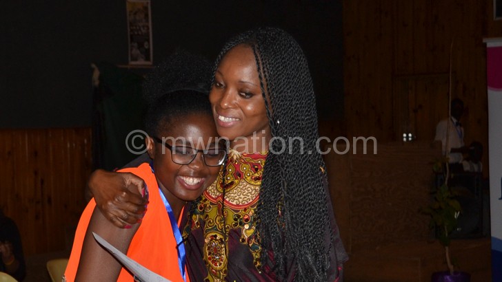 Tawile smiles as she is hugged by Malawi’s top designer Lilly Alfonso (R)