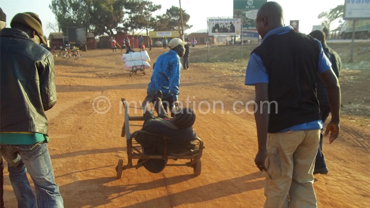 An excessively drunk woman being carried home at Jenda Trading Centre in Mzimba