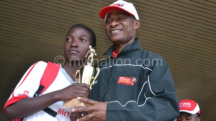 Chawinga (L) receives her best player trophy from Kyumba
