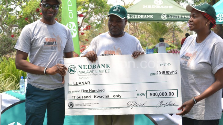 Nedbank Malawi MD Paul Guta (L) poses with a dummy cheque with Kanyama-Phiri (C) and Mbuyane-Mokone