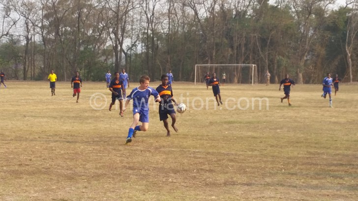 St Andrew’s defender (in blue) tried to shield the ball from Ndirande Hill striker