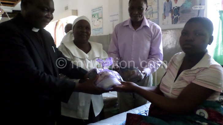 Leader of delegation Reverend Collins Bhuda (L) and other chaplaincy members 
present gifts to an expectant mother at Bangwe Health Centre