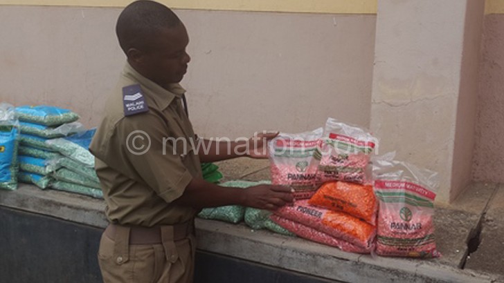 Limbe Police Station deputy spokesperson Pedzisai Zembeneko shows the reporter some of the confiscated fake seeds