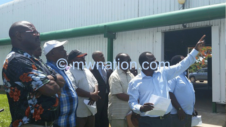 Chiyembekeza (in white cap) and other officials 
being briefed on the plant