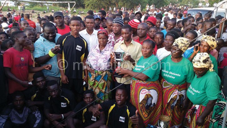 The elderly and the youth pose with football officials after the match