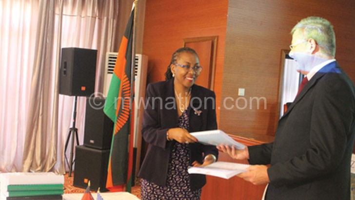 Banda (L) and Bushney exchanging documents