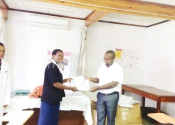 QECH’s Phylos Bonongwe (R) 
presents a uniform to a nurse