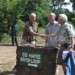 Hay (L) shakes hands with Taylor after unveiling the road sign 
as David Hayes looks on