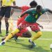 A Cameroon player shields the ball from Yamikani Chester