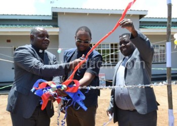 Synod moderator the Reverend Masauko Mboembole cuts the ribbon to symbolise opening of the building