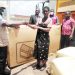 Kalemba presents a housing unit to a flood victim