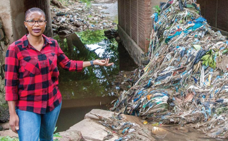 Majiga poses in waste-infested Mudi River