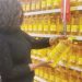 Women appreciate the price of imported oil at a supermarket