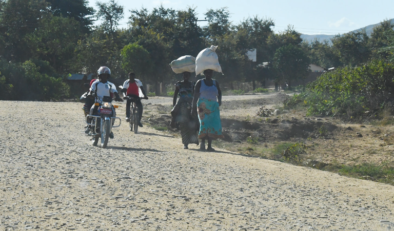 People travel on the first part of the East Bank road from Thabwa
